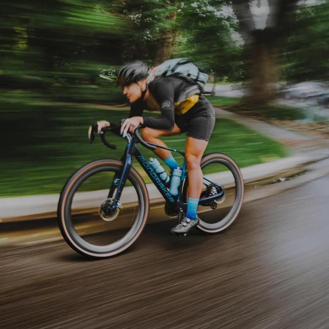 Vélos de gravel Frau auf einem Gravel Bike auf der Straße